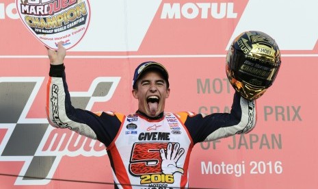 Pembalap Honda, Marc Marquez merayakan kemenangan di podium sirkuit Motegi, Jepang, Ahad (16/10). Kemenangan membuat Marquez menjadi juara dunia MotoGP 2016.