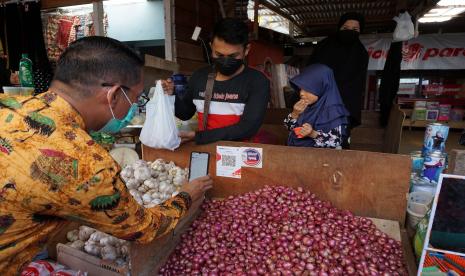 Pembeli bertransaksi menggunakan barcode Quick Response Code Indonesian Standard (QRIS) saat transaksi non tunai di Pasar Remu Kota Sorong, Papua Barat, Kamis (2/12/2021) (ilustrasi). PT Bank Pembangunan Daerah Papua atau Bank Papua menyampaikan, kondisi memasuki masa endemi yang ditandai dengan pelonggaran penggunaan masker diperkirakan dapat mempercepat laju pertumbuhan ekonomi di Bumi Cendrawasih.