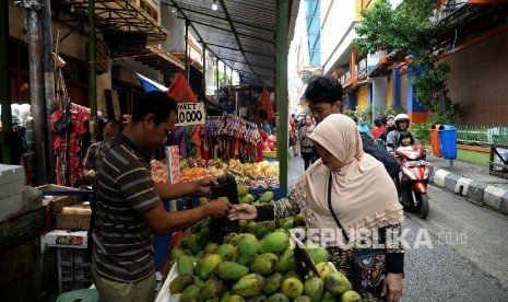 Pembeli melihat barang yang dijual pedagang kaki lima (PKL) di Pasar Balimester, Jatinegara, Selasa (23/11).