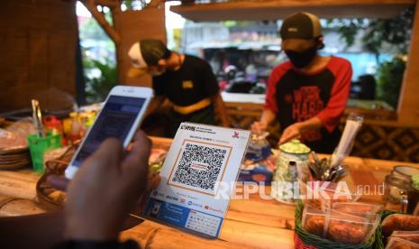 Pembeli membayar dengan metode scan Quick Response Code Indonesian Standard (QRIS) di warung KE Angkringan, Ampera, Jakarta, Jumat (30/7).  Bank Indonesia (BI) mencatatkan realisasi penggunaan metode pembayaran quick response code Indonesia standard (QRIS) sebanyak 7,85 juta merchant pada kuartal II 2021.