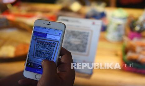 Pembeli membayar dengan metode scan Quick Response Code Indonesian Standard (QRIS) di warung KE Angkringan, Ampera, Jakarta. Wakil menteri perdagangan Jerry Sambuaga terus menggenjot digitalisasi pasar dan transaksi. Oleh karena itu ia terus melakukan sosialisasi dan menghimbau stake holder agar memanfaatkan QRIS (Quick response code Indonesian Standard) secara optimal. 