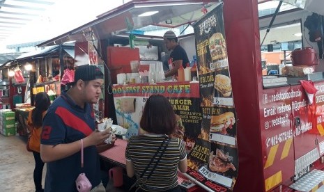 Pembeli membeli makanan di food truck Kompleks Olahraga Bukit Jalil, Selangor, Senin (21/8).