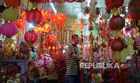 Pembeli mengamati pernak-pernik khas Imlek di pasar tradisional Pancoran di Kawasan Petak Sembilan, Glodok, Jakarta Barat, Ahad (7/2). (Republika/Yasin Habibi)