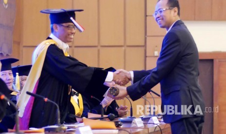 Pemberian gelar Doktor yang diserahkan Rektor Unpad Prof Dr med Tri Hanggono Acmad kepada Dirut Bank BJB Ahmad Irfan usai sidang Promosi Doktor dirinya di Aula Unpad, Jl Dipatiukur, Kota Bandung, Senin (14/8).