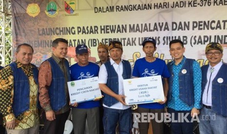 Pemberian kredit KUR dan KCR kepada peternak binaan Bank BJB disaksikan oleh Bupati Kabupaten Bandung H Dadang M Naser (tengah) serta Pemimpin Wilayah I Bank BJB Isa Anwari (kedua kiri), di Pasar Hewan Majalaya, Kabupaten Bandung (12/4).