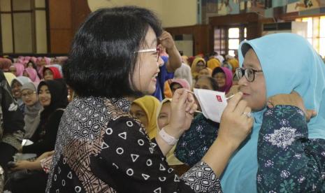 Pembina Ikatan Istri Karyawan Semen Indonesia (IIKSMI), Netty Doddy Sulasmono Diniawan turut mengedukasi cara penggunaan masker yang benar, pada sosialisasi pola hidup sehat (PHS) untuk mendukung pencegahan virus Corona kepada warga di sekitar PT Semen Indonesia (Persero) Tbk (SIG), Kamis (12/3). 