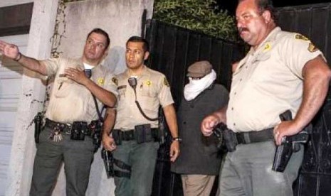 Pembuat film anti-Islam, Nakoula Basseley, menggunakan selendang putih untuk menutup muka digelandang oleh polisi Los Angeles. Kejaksaan wilayah LA menyatakan, Nakoula, resmi ditahan Kamis (27/9/2012)