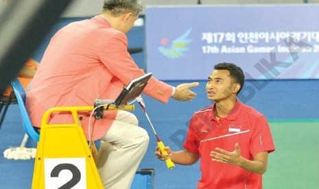 Pembulu tangkis putra Indonesia Tommy Sugiarto memprotes keputusan wasit ketika Indonesia bertemu Taiwan pada babak penyisihan bulu tangkis putra Asian Games 2014 di Gyengyang, Gymnasium, Inceon, Korea Selatan, Ahad (21/9).