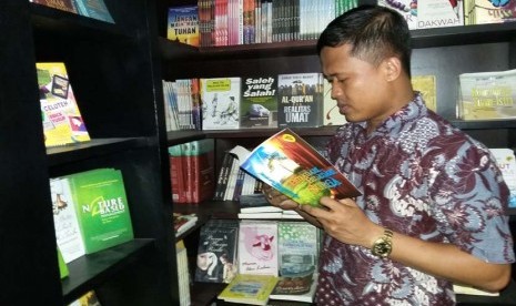 Pemenang kedua Bilik Sastra Award 2015 Agus Purwanto tengah menyimak novel Bidadari-Bidadari Surga karya Tere Liye di Toko Buku Republika, Jakarta, Senin (2/11).