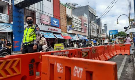 Petugas mengatur rekayasa lalu lintas ganjil-genap di Jalan Ahmad Yani, Kabupaten Garut, Jumat (6/8).