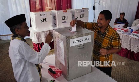 Pemilih memasukkan surat suara di sebuah TPS di Jatipadang pada Pilkada DKI Putaran 2, Rabu (19/2).