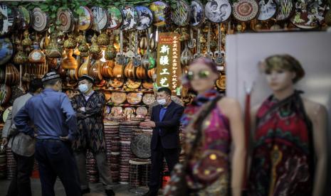 Pemilik kios di Grand Bazaar di Urumqi, Xinjiang berbincang dengan pengunjung, 21 April 2021.