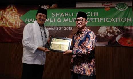 Pemilik Restoran Shabu Hachi (kiri) menerima sertifikat halal MUI yang diserahkan oleh Direktur LPPOM-MUI Lukmanul Hakim (batik) di Resto Shabu Hachi cabang Bogor, Kamis (30/8). Selain menerima sertifikat halal, Shabu Hachi juga meraih rekor MURI.