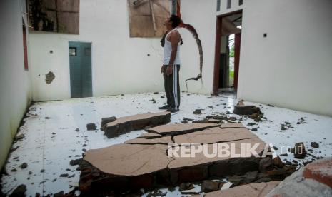 Pemilik rumah melihat kondisi rumahnya yang rusak akibat tanah bergerak di Desa Sudamanik, Lebak, Banten, Senin (1/2/2021). Hujan dengan intensitas tinggi telah menyebabkan tanah bergerak sehingga merusak sebanyak 41 rumah, tiga diantaranya ambruk .