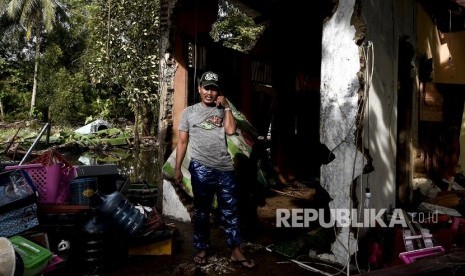 Pemilik rumah singgah berada didepan bangunan miliknya yang hancur akibat terjangan gelombang tsunami Selat Sunda di Anyer Carita, Banten, Rabu (26/12/2018).