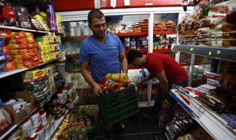 Pemilik toko membuang produk-produk Israel dari tokonya di Tepi Barat, Nablus, Kamis (7/8). 