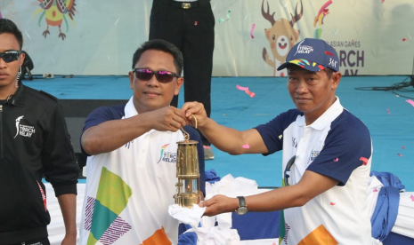 Pemimpin BNI Wilayah Papua Suhardi Petrus menyerahkan Obor Asian Games 2018 kepada Kepala Dinas Parawisata Papua Barat Yusdi Lamatenggo dalam prosesi Kirab Obor Asian Games 2018 di Waisai, Raja Ampat, Papua Barat, Kamis (26 Juli 2018).