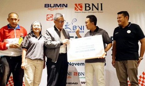 Pemimpin Divisi Komunikasi Pemasaran BNI Indomora Harahap (Kedua Kanan) menyerahkan mock up hadiah tabungan sebesar Rp 250 juta kepada Ketua Umum PP Pelti Rildo Ananda Anwar (tengah) disaksikan Legenda Tennis Yustedjo Tarik (Kiri), Tournament Director dan Wakil Sekjen Pengurus Pelti Susan Subakti (kedua kiri) dan GM Corporate Secretary and Communication Arry Herwindo (kanan) pada acara Konferensi Pers BNI Tennis Open 2019 di Jakarta, Kamis (14/11). 