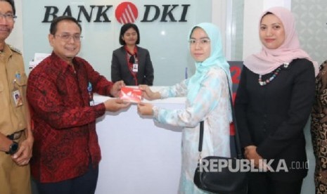 Pemimpin Grup Pengembangan Jaringan Bank DKI, Romy Wijayanto (kiri) berfoto bersama nasabah Bank DKI usai peresmian relokasi Kantor Layanan Gatot Subroto dari gedung Gedung SME Tower UMKM ke Jl. Mampang Prapatan Raya No. 68-B, Jakarta (19/08). 