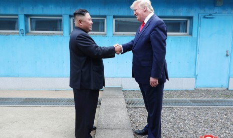 Pemimpin Korea Utara (Korut) Kim Jong-un dan Presiden AS Donald Trump bertemu di Panmunjong di Zona Demiliterisasi, Ahad (30/6).