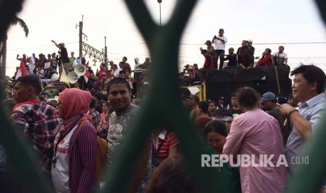 Pemimpin orasi berbaju hitam, memprovokasi massa hingga terjadi pelemparan air mineral cup, sementara pemimpin orasi berbaju putih, mencoba menenangkan.