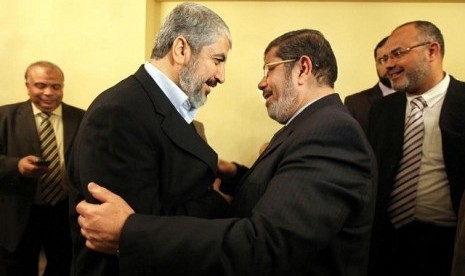 Pemimpin politik Hamas, Khaled Misyal (kiri), saat bertemu Presiden Mesir, Muhammad Mursi (kanan) di Kairo.