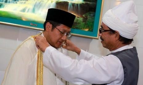 Pemimpin pondok pesantren Al-Kautsar Al-Akbar Buya Syekh Ali Akbar Marbun memakaikan jubahnya kepada Ketua Umum DPP Partai Demokrat (PD) Anas Urbaningrum