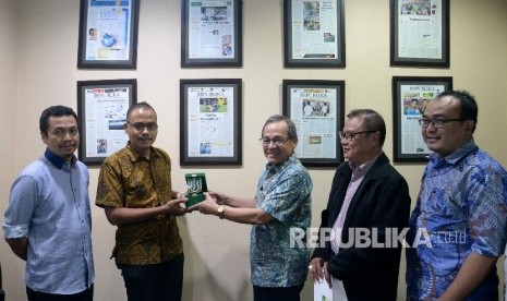 Pemimpin Redaksi Republika Irfan Junaidi (kedua kiri) menerima cinderamata dari Direktur Sekolah Pascasarjana Universitas Nasional (UNAS) Maswadi Rauf (ketiga kanan) didampingi Redaktur Pelaksana Republika Subroto (kiri), Wakil Direktur Sekolah Pascasarjana UNAS Firdaus Syam (Kedua Kanan) dan Direktur Pascasarjana Ilmu Politik Sekolah Pascasarjana UNAS M.Alfan Alfian M saat berkunjung ke kantor Harian Republika, Jakarta, Rabu (23/8).