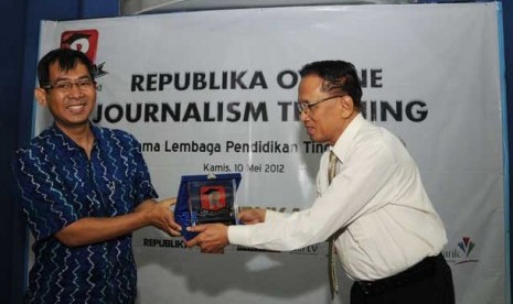 Pemimpin Redaksi Republika, Nasihin Masha (kiri) menyerahkan plakat kepada Direktur P3M Universitas Persada Indonesia Y.A.I, Prof Anoesyirwan Moeins (kanan) saat membuka acara Republika Online Journalism Training di Kampus YAI, Jakarta,Kamis (10/5).