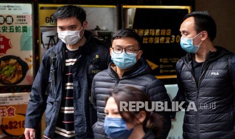  Pemimpin Redaksi Stand News Patrick Lam (tengah) ditangkap oleh petugas departemen keamanan nasional kepolisian Hong Kong dalam penggerebekan kantor outlet media di Hong Kong, Cina, 29 Desember 2021. Lebih dari 200 petugas polisi menggerebek outlet media online Stand News dan menangkap setidaknya enam orang yang terhubung ke platform untuk konspirasi untuk menerbitkan publikasi hasutan, yang melanggar bagian 9 dan 10 dari Undang-undang Kejahatan. 