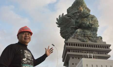 Pemrakarsa Patung Garuda Wisnu Kencana (GWK) Nyoman Nuarta berfoto dengan latar belakang Patung GWK di Ungasan, Badung, Bali, Selasa (31/7).