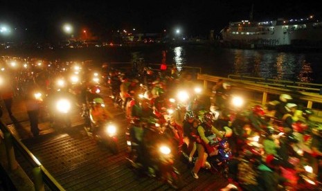   Pemudik berkendaraan sepeda motor antre masuk ke kapal roro di Pelabuhan Merak, Banten, Kamis (16/8) malam. (Agung Supriyanto/Republika)