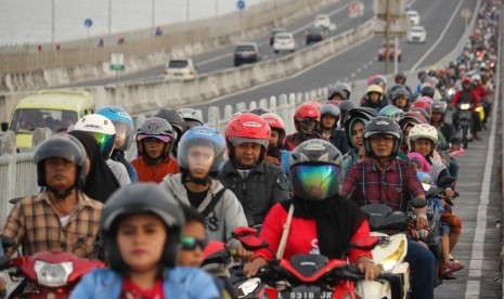 Pemudik dengan menggunakan kendaraan bermotor roda dua melintas di Jembatan Suramadu, Surabaya, Jawa Timur, Selasa (4/6/2019). 