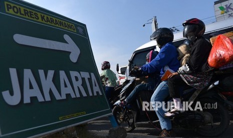 Pemudik dengan sepeda motor melintasi Jalan Raya Klari, Karawang, Jawa Barat, Sabtu (23/6)