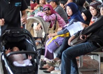 Pemudik duduk di ruang tunggu di terminal 1 Bandara Soekarno Hatta, Jakarta, Jumat (26/8). 