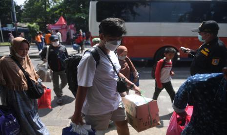 Pemudik membawa barang setibanya di Terminal Kampung Rambutan, Jakarta, Sabtu (7/5/2022). Terminal Kampung Rambutan di Jakarta Timur telah melewati puncak arus balik Lebaran 2022, yakni pada H+3 Lebaran.