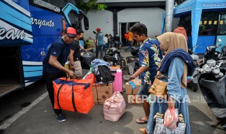 Pemudik menaikan barang bawaannya ke dalam bagasi bus di Terminal Tanjung Priok, Jakarta Utara, Rabu (3/4/2024). Seminggu menjelang hari raya Idul Fitri 1445 Hijriah, jumlah  penumpang di Terminal Tanjung Priok berangsur naik hingga 30 persen dari hari biasanya dengan rata-rata tujuan akhir ke Jawa Tengah dan Jawa Timur. Pemudik mengaku memilih berangkat mudik lebih awal lantaran menghindari harga tiket bus yang berangsur naik. Sementara Pemerintah melalui Kementerian Perhubungan memprediksi jumlah pemudik tahun ini mencapai 193,6 juta orang atau mengalami kenaikan hingga 60 persen dari tahun lalu yang berjumlah 123,8 juta orang pemudik. Kemudian, untuk puncak  arus mudik Lebaran 2024 diprediksi akan terjadi pada tanggal 5-7 April mendatang.