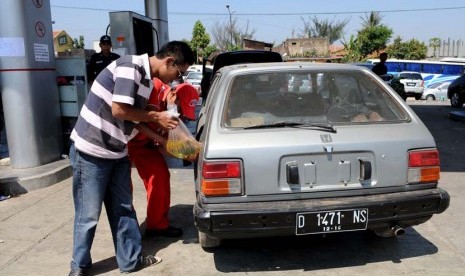  Pemudik mengisi kendaraan mereka dengan bahan bakar yang dibeli dari SPBU terdekat dengan mengunakan kantong plastik akibat habisnya stok BBM di sebuah SBPU di kawasan Cicalengka, Kabupaten Bandung, Jawa Barat (18/8). (Prayogi)