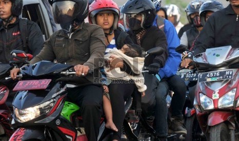  Pemudik motor membawa anak mereka yang masih kecil saat melintas di kawasan Karawang, Jawa Barat. ilustrasi