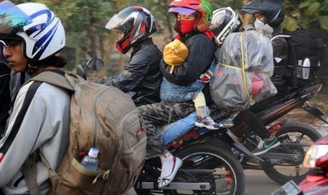   Pemudik sepeda motor dengan muatan barang yang melebihi batas melintas di jalur alternatif Cilamaya-Cikalong, Karawang, Jawa Barat, Jumat (17/8).  (Aditya Pradana Putra/Republika)