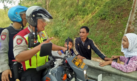 Pemudik Terlantar: Tim Urai Satlantas Polres Purwakarta, saat mengevakuasi pemudik yang terlantar di KM 76 Tol Cipali, Ahad (9/6). Kabarnya, mereka kehabisan ongkos sehingga diturunkan ditengah jalan oleh sopir bus jurusan Jakarta. 