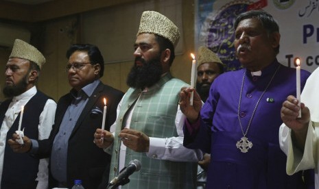 Pemuka agama dari berbagai agama di Lahore, Pakistan menyalakan lilin sebagai bentuk peringatan bagi korban bom Paskah di Sri Lanka, Rabu (24/4).