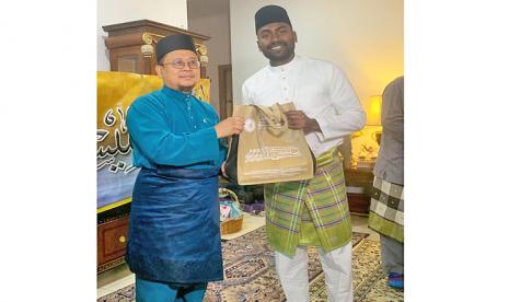 Pemuka agama di Unit Dakwah Islam Brunei Darussalam Haji Ahmad Abdussalam bin Haji Abdul Rahman menyerahkan hadiah kepada pria India Muhammad Gana bin Vijayan yang baru memeluk Islam, 26 November 2022. Seorang Pria India Memeluk Islam di Brunei Darussalam