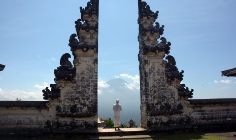 Pemuka Agama Hindu berjalan di Pura Lempuyang dengan latar Gunung Agung di Karangasem, Bali, Rabu (27/9). 