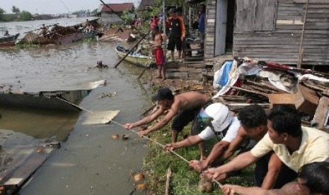 PEMUKIMAN LONGSOR. Warga menarik sebuah rumah yang hanyut ke sungai akibat terjadinya longsor di pemukiman warga Kelurahan Pengambangan, kota Banjarmasin, Kalsel, Sabtu (13/8). Sedikitnya lima rumah hanyut ke sungai setelah jalan di pemukiman tersebut long