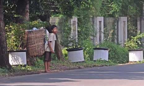 Pemulung cilik berjalan saat mencari sisa sampah di daerah Pondok Gede, Jakarta Timur, Jumat (16/5).