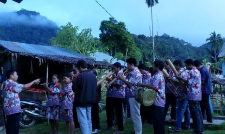 Pemusik bambu Desa Mapahi menyanyikan lagu Naik Gunung dengan latar belakang kabut menyelimuti lereng Gunung Ntoriate.