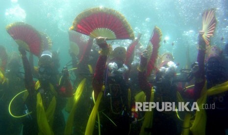 Penari memperagakan tarian Gandrung di bawah laut di Zona Konservasi Bunder, Banyuwangi, Jawa Timur, Rabu (4/4). 