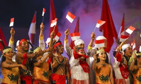 Penari mengibarkan bendera merah putih saat Konser Kolosal Gelar Seni Budaya dalam rangkaian peringatan Hari Sumpah Pemuda di Lapangan Pancasila Graha Sabha Pramana UGM, Jumat (30/10)