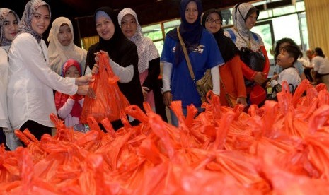 Penasehat Dharma Wanita Persatuan Dharma Wanita Persatuan Kemendes PDTT Ari Haryati Marwan Jafar (kiri) melayani pengunjung Pasar Murah Menyambut Ramadan di Balai Makarti Muktitama, Kalibata, Jakarta Selatan, Rabu (1/6/2016). 